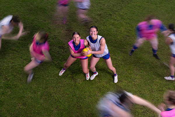 Two footy players holding the football