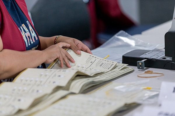 A woman counting ballot papers following a state election