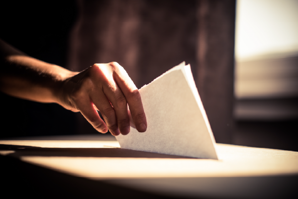 Hand putting vote into ballot box