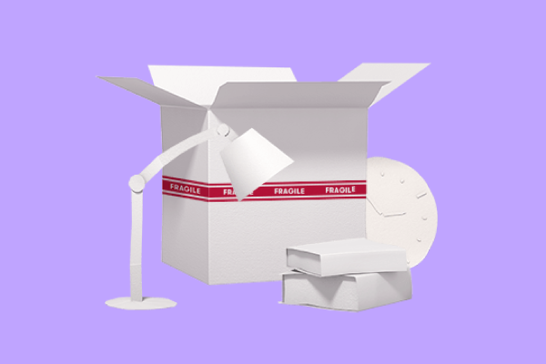 Moving box with lamp, stack of books, and clock waiting to be packed into it