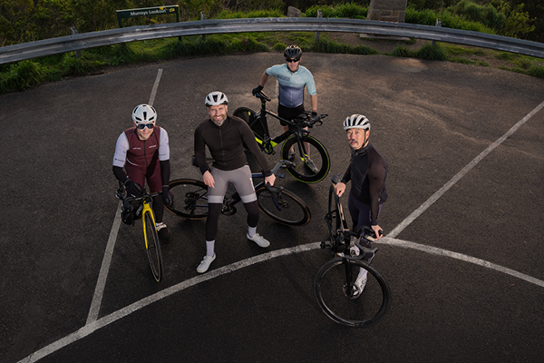 Four cyclists standing next to their bikes