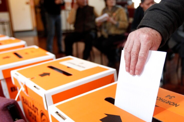 Hand putting vote into ballot box